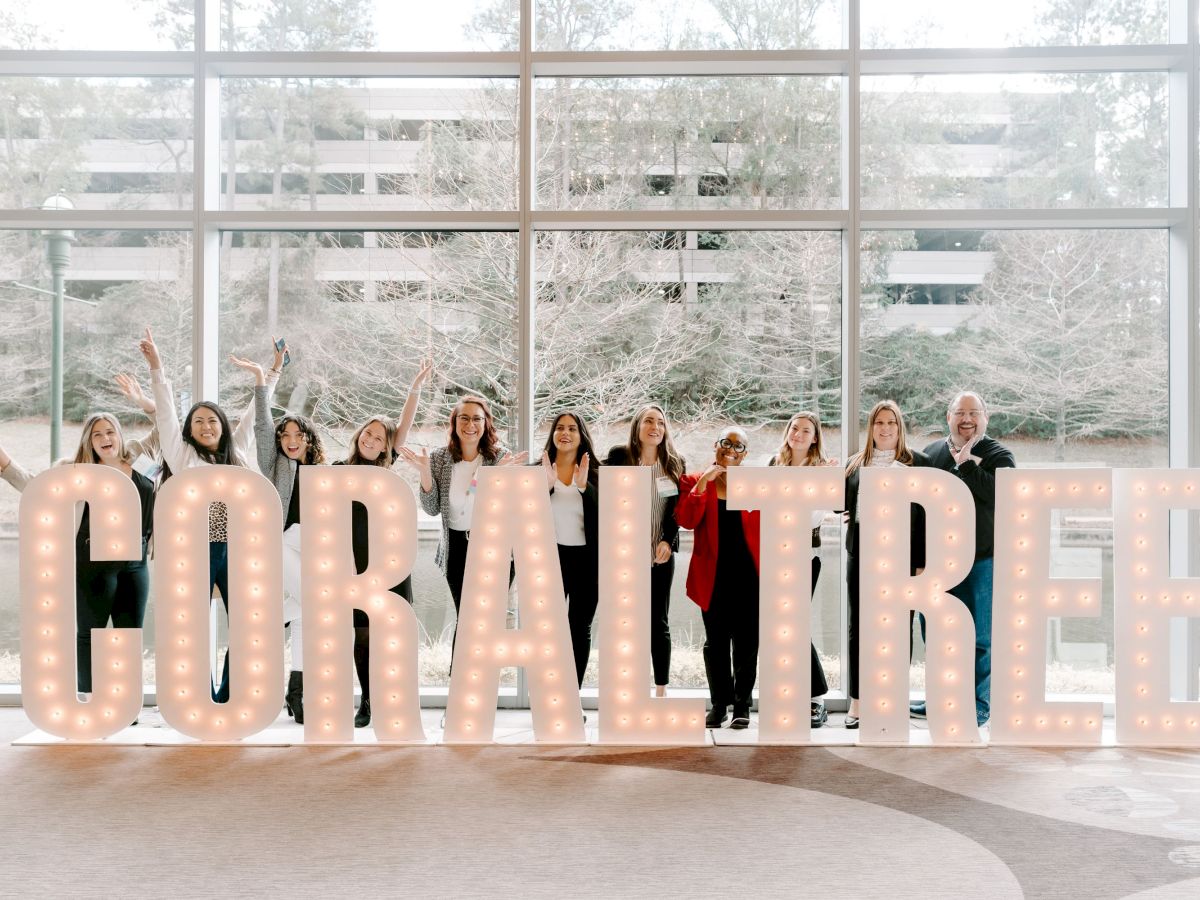 A group of people standing behind large, illuminated letters spelling 